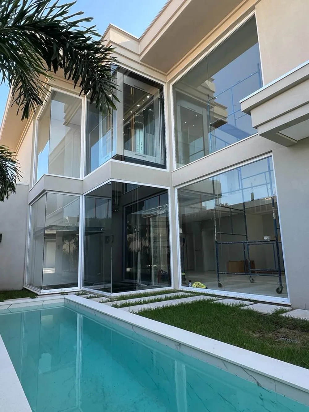 Elevador interno visível através da casa em vidro, vista da área de lazer